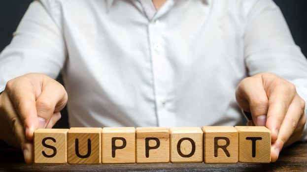 Man holding wooden blocks saying support