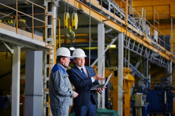 Two men in hardhats at manufacturing plant