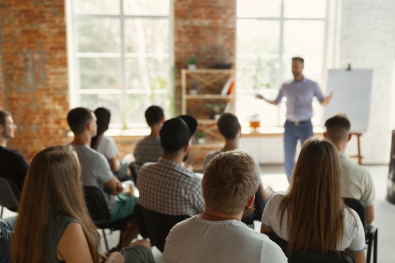 Person presenting a training course with a flip board to a room of professionals