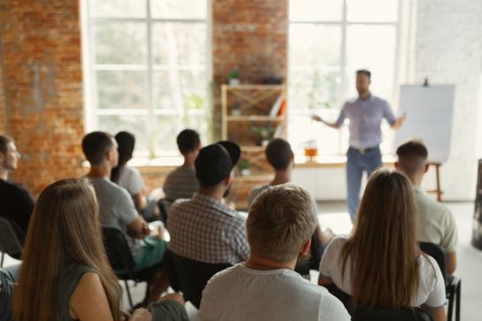 Person presenting a training course with a flip board to a room of professionals